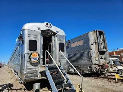 Two train cars are parked next to each other on the tracks.
