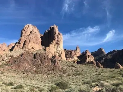 A large rock formation in the middle of a desert.
