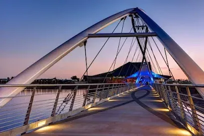 A bridge over a body of water with a building in the background