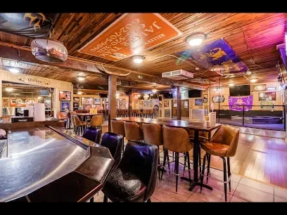 A restaurant with tables and chairs and a sign on the ceiling.
