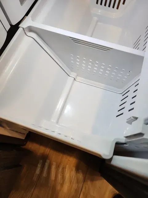 the inside of a refrigerator with a basket in it