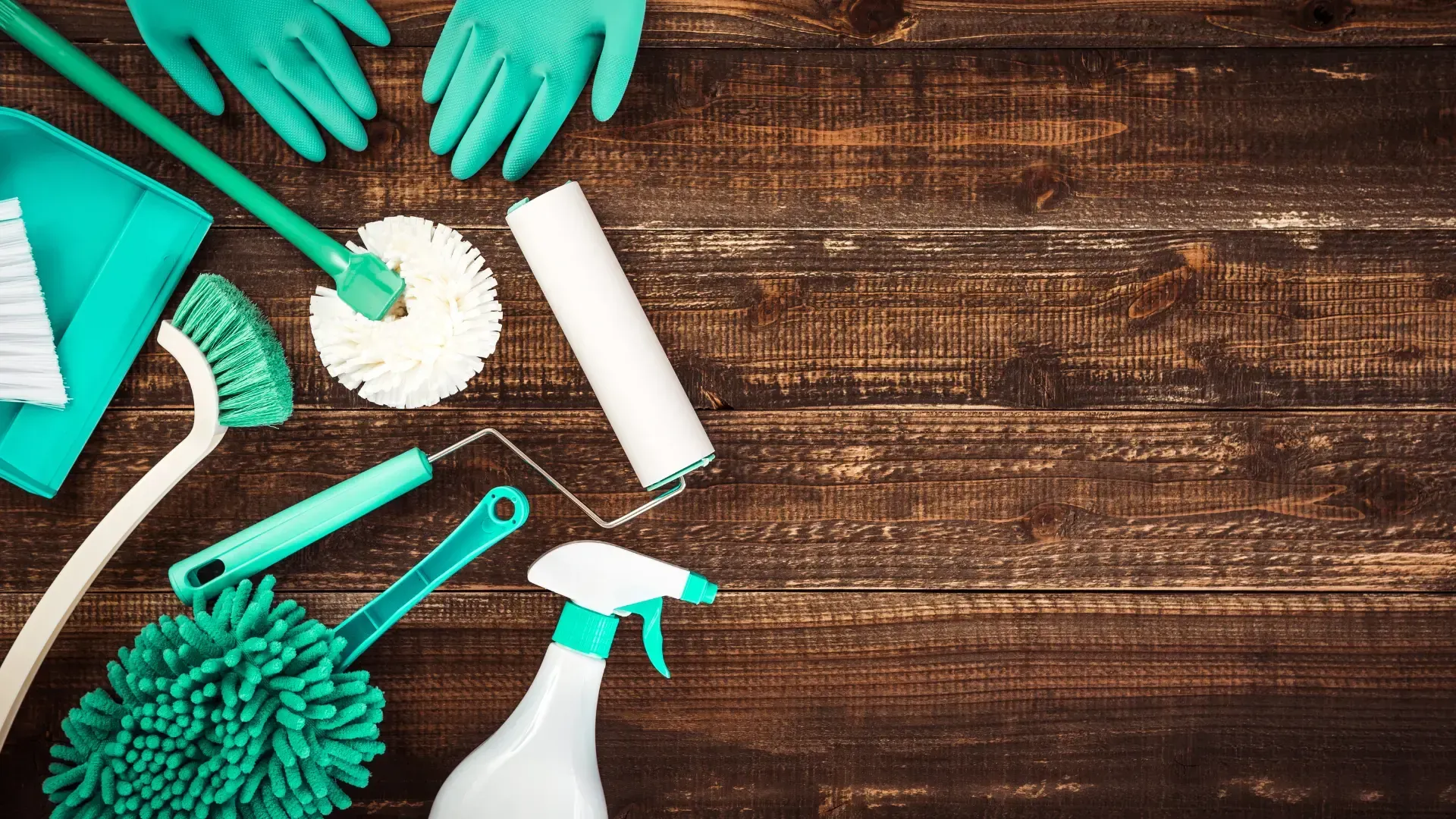 A wooden table topped with cleaning supplies and gloves.