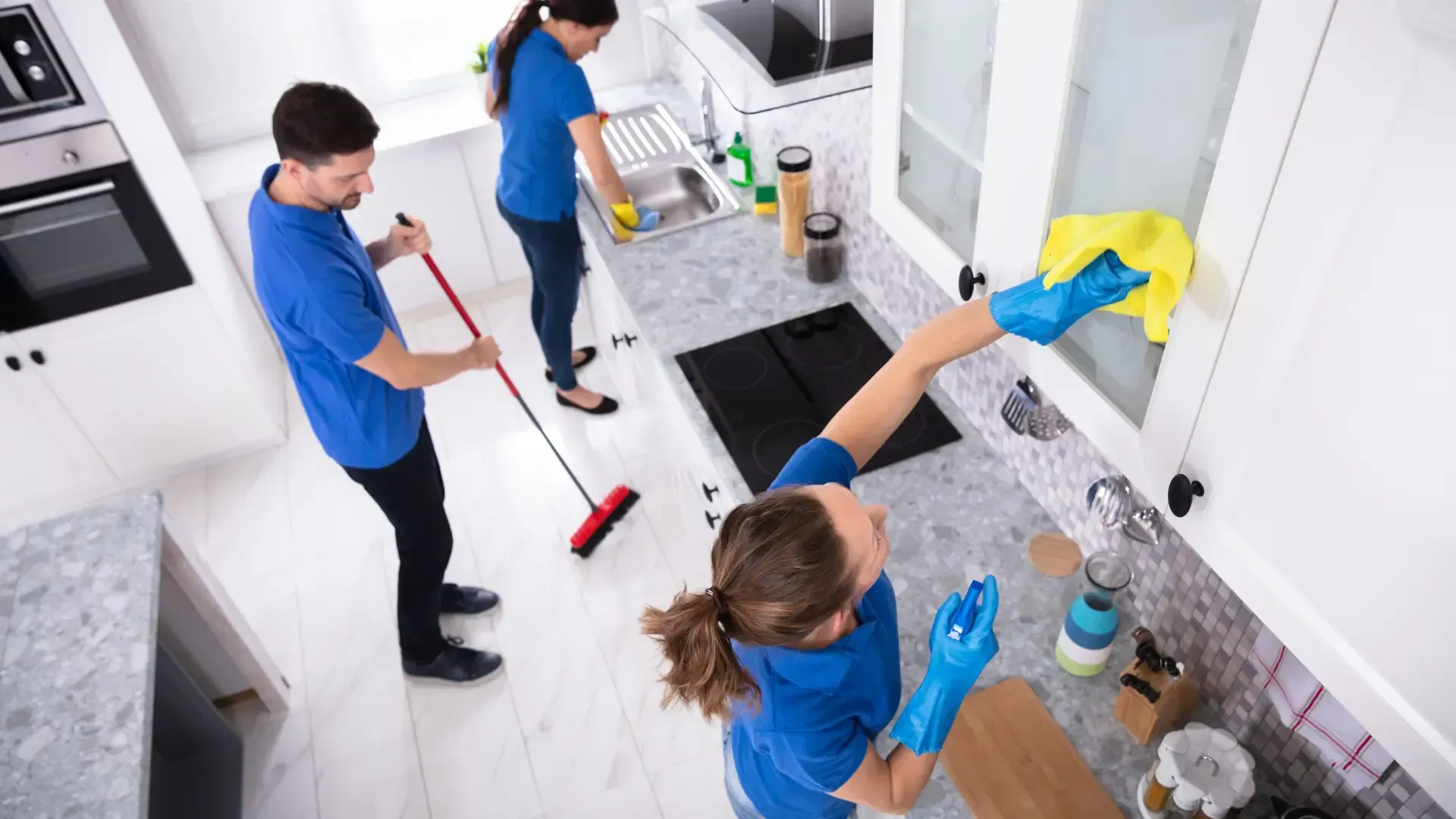 A group of people are cleaning a kitchen.