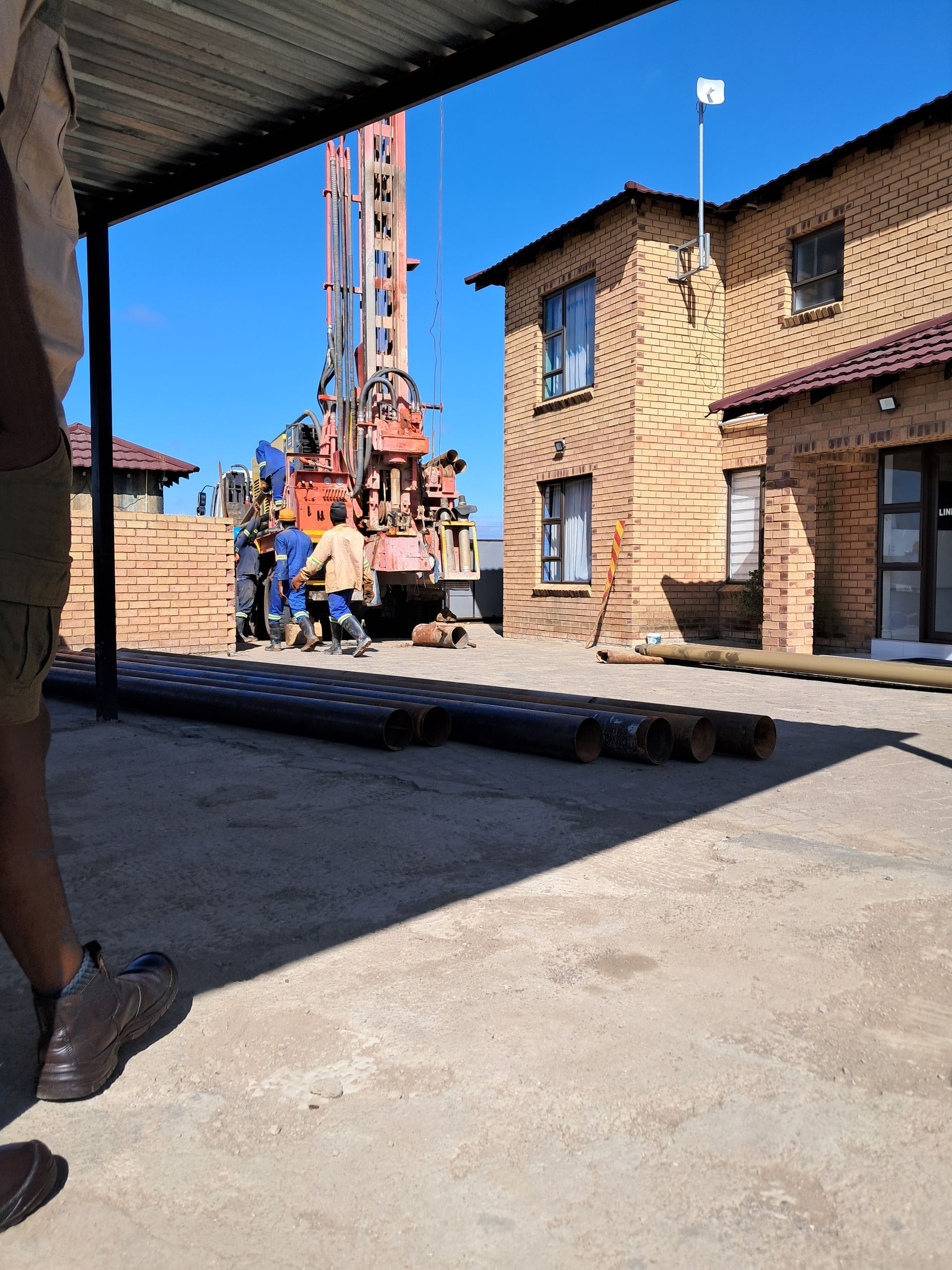A man standing in front of a building with a crane in the background