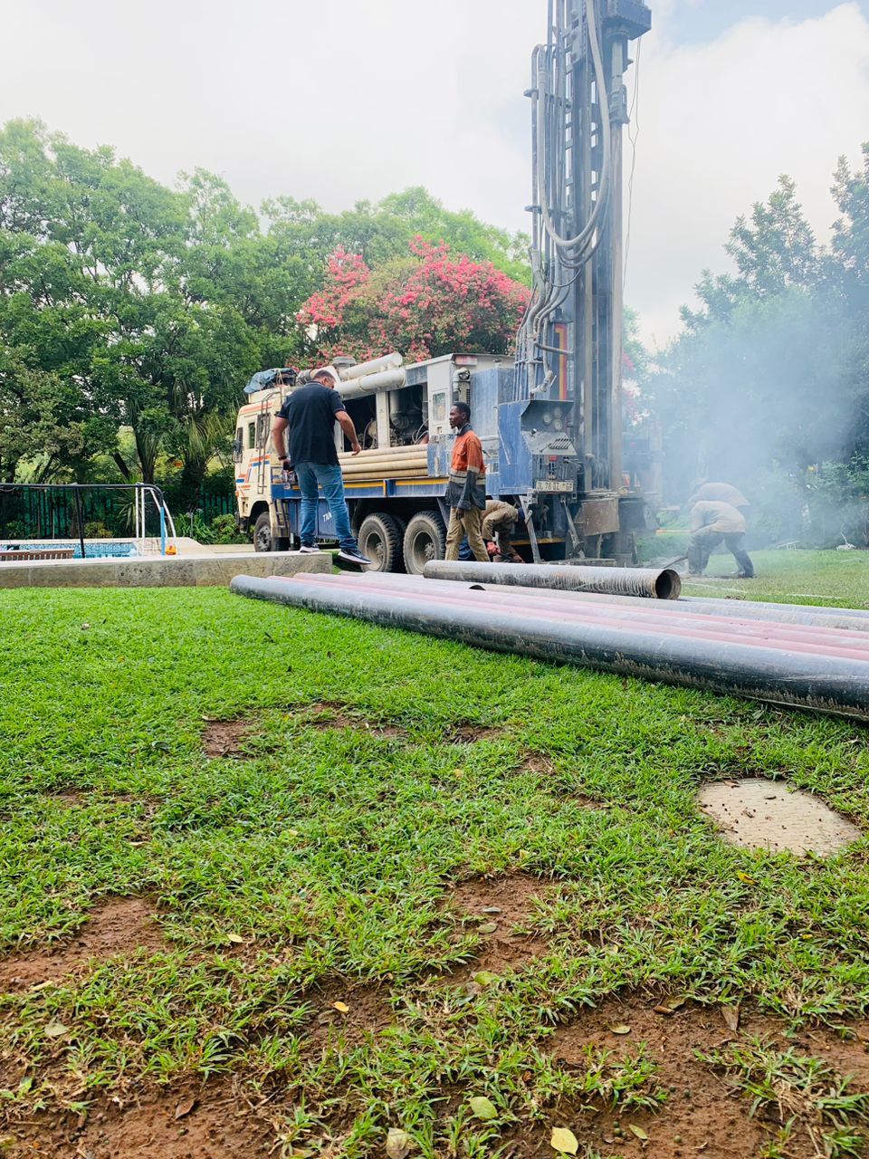 A truck is drilling a hole in the ground in a park.