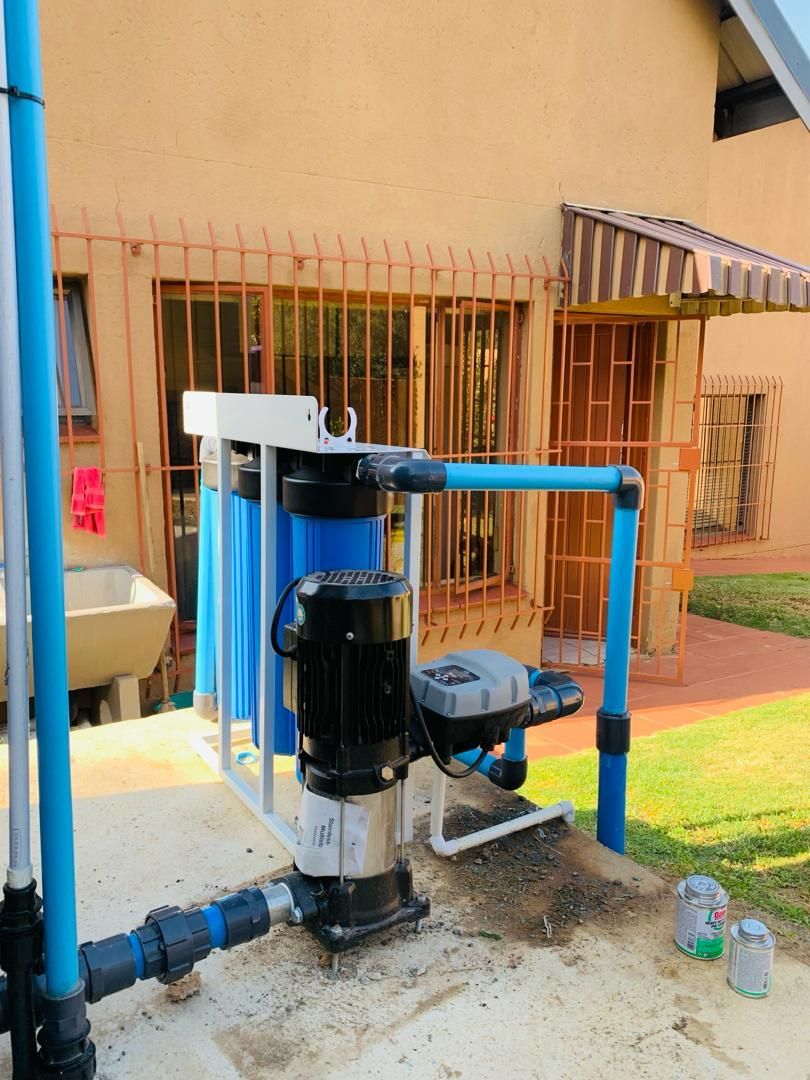 A water pump is sitting in front of a house.