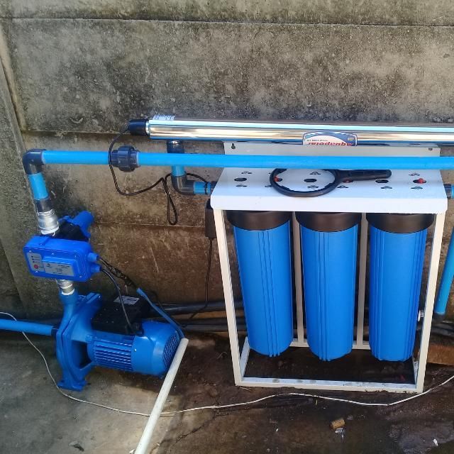 A blue water filter with a pump attached to it