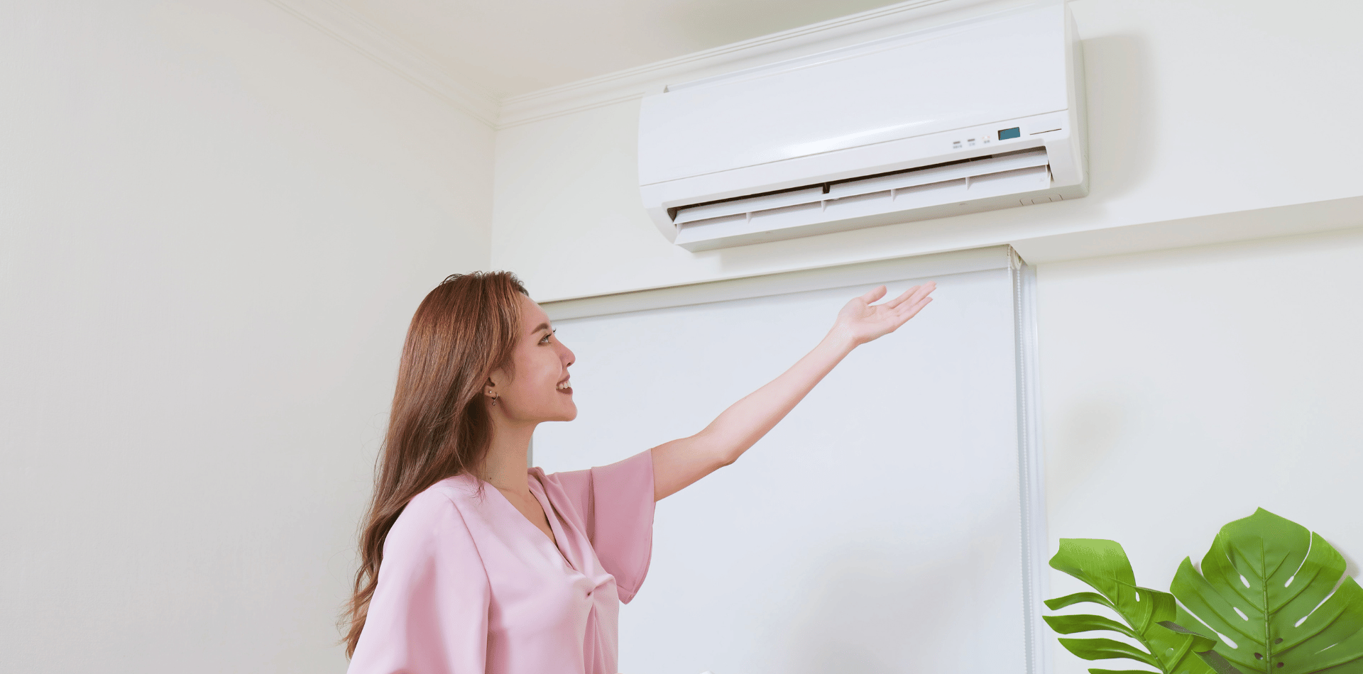 A woman controlling an air conditioner