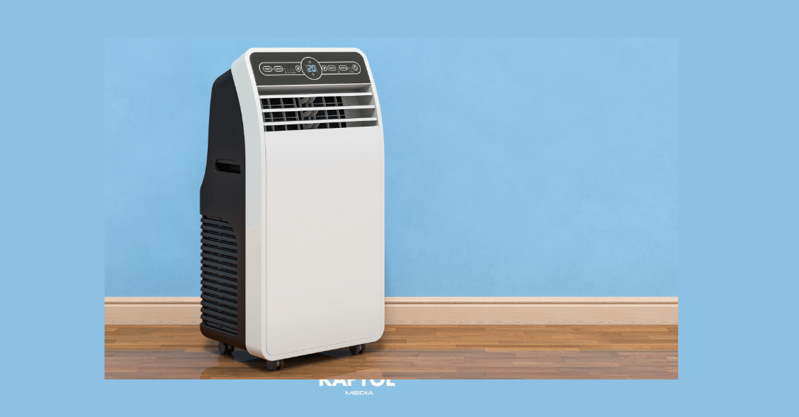 A portable air conditioner is sitting on a wooden floor in front of a blue wall.