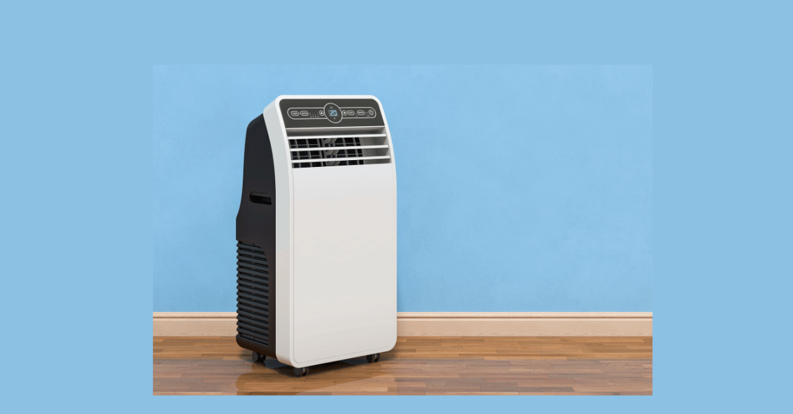 A portable air conditioner is sitting on a wooden floor in front of a blue wall.