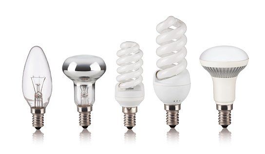A row of different types of light bulbs on a white background