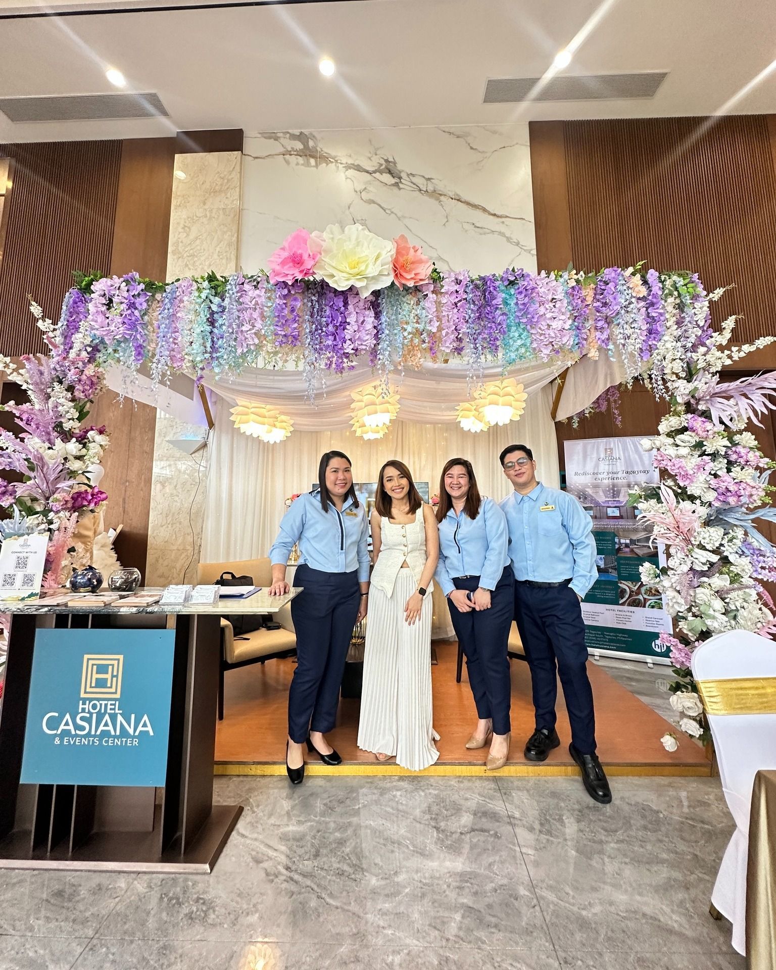 A group of people are posing for a picture in a room decorated with flowers.