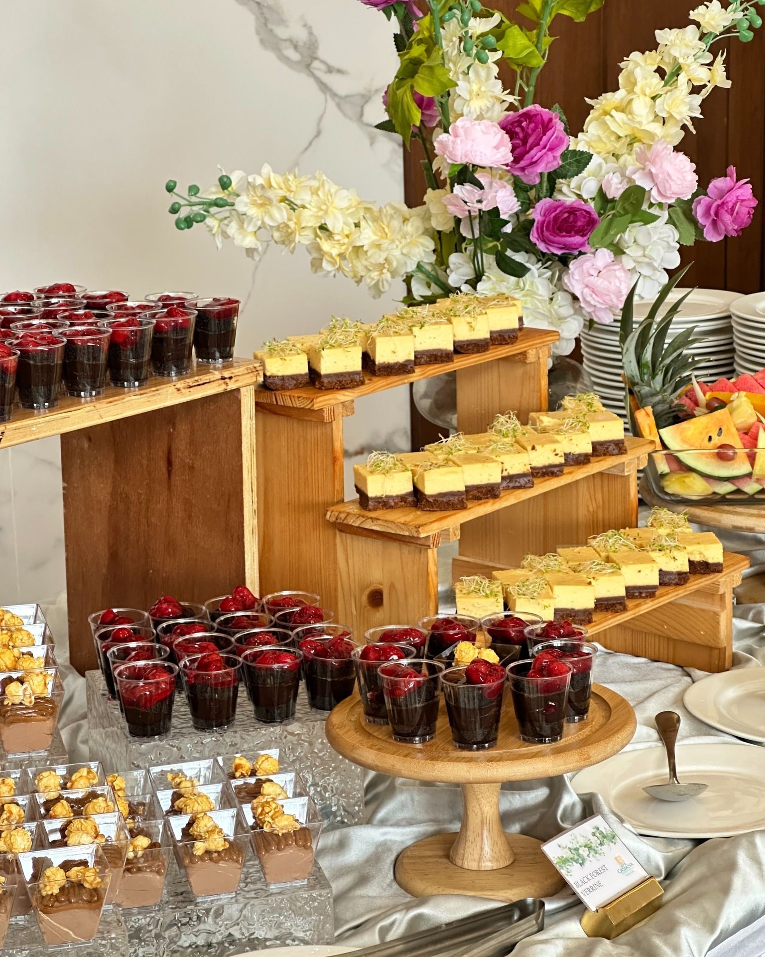 A buffet table filled with lots of desserts and fruit.