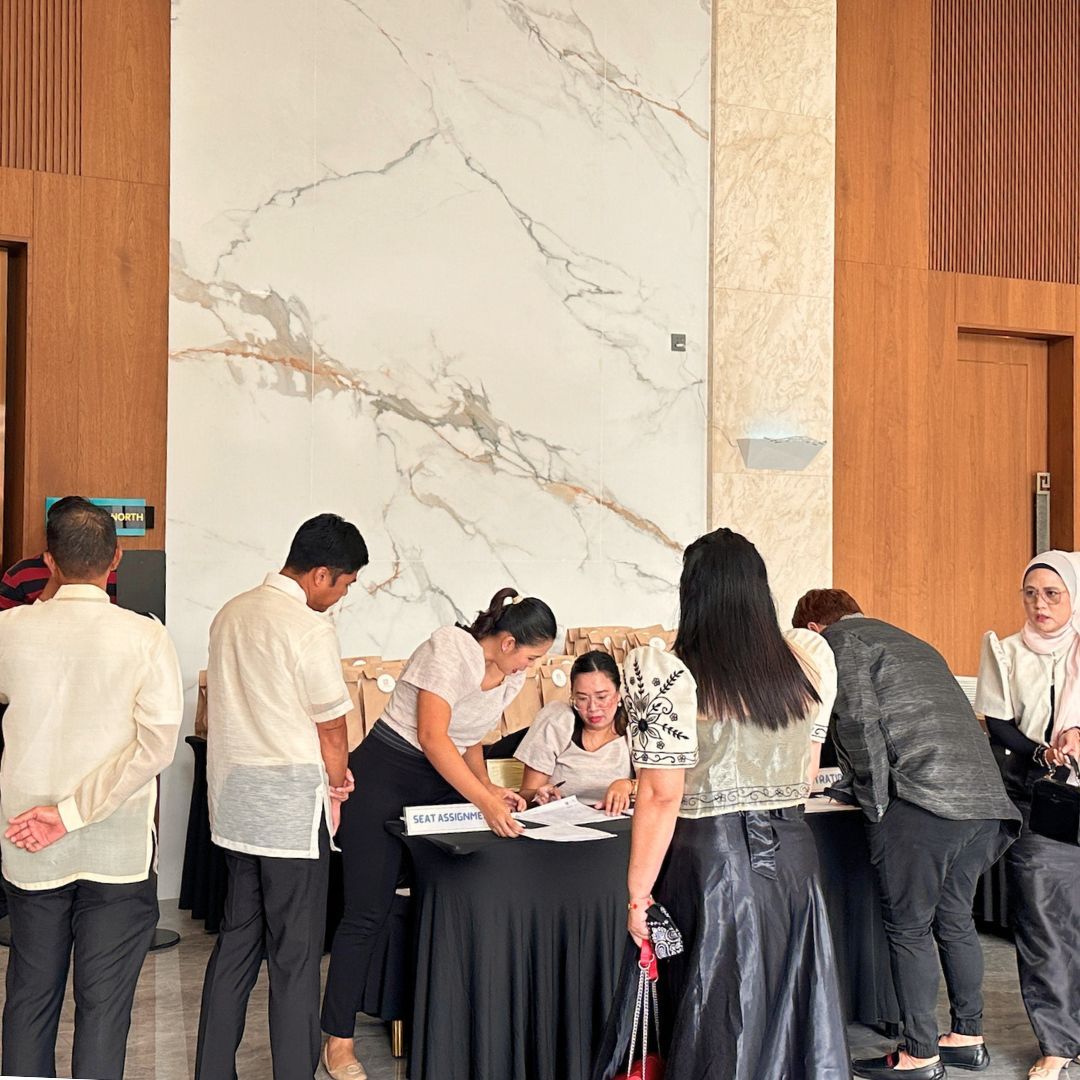 A group of people are standing around a table in a room.