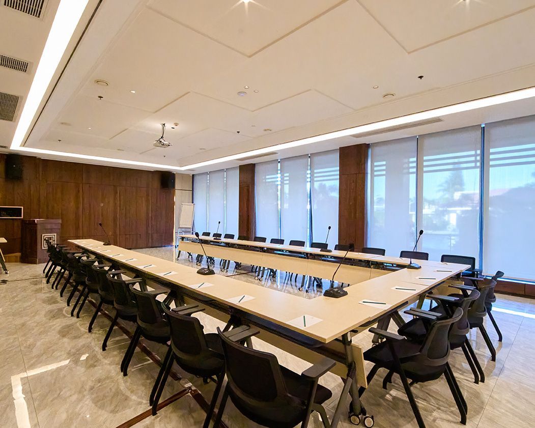 A large conference room with a long table and chairs.
