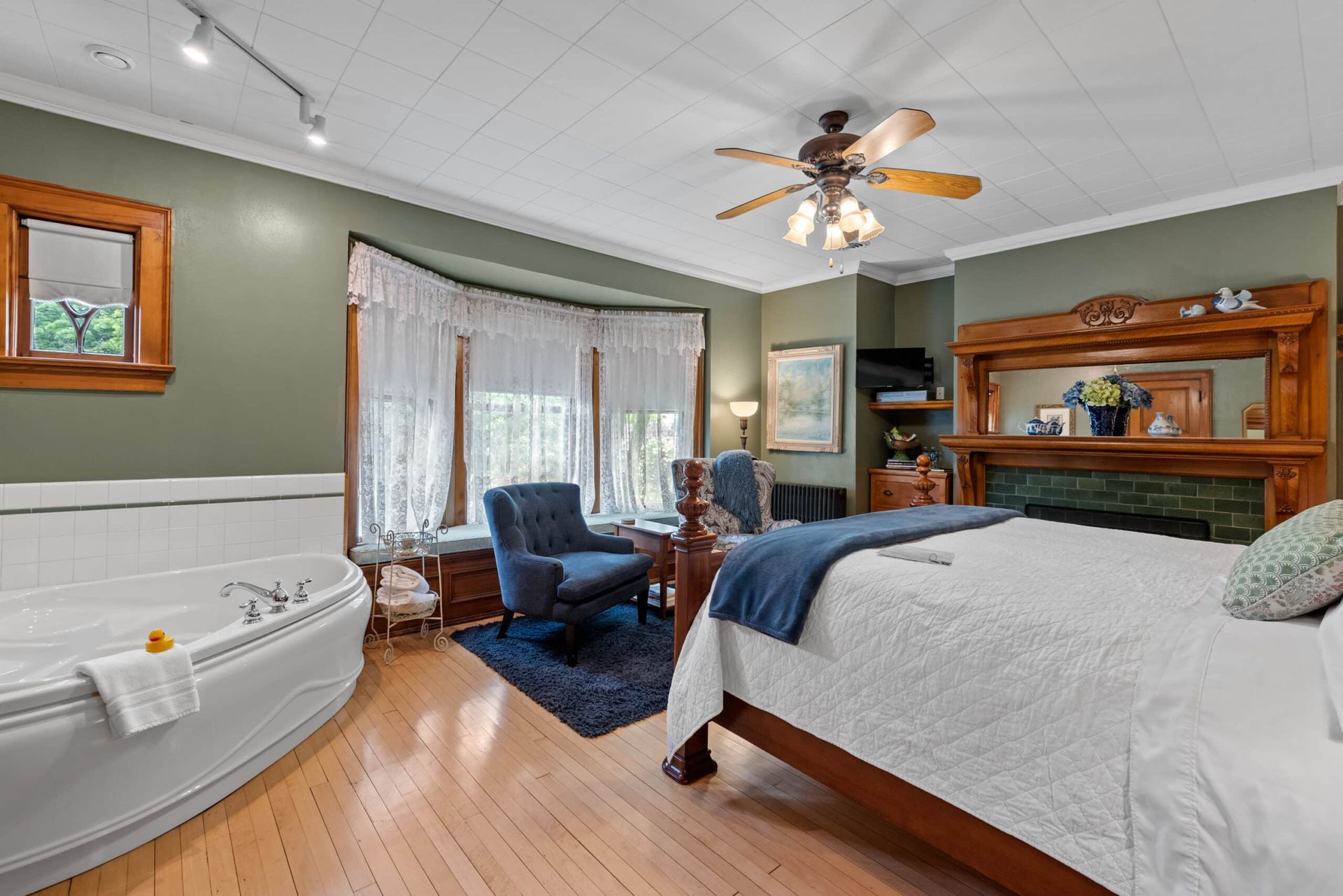 A bedroom with a king size bed and a jacuzzi tub.