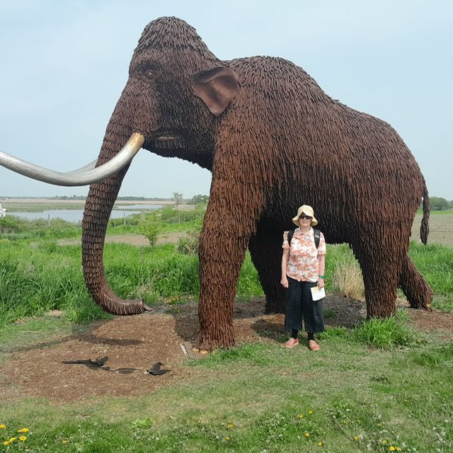 A woman stands in front of a statue of an elephant