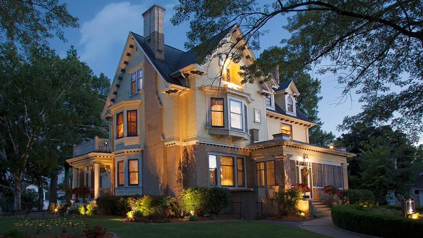 A large house with lots of windows is lit up at night.