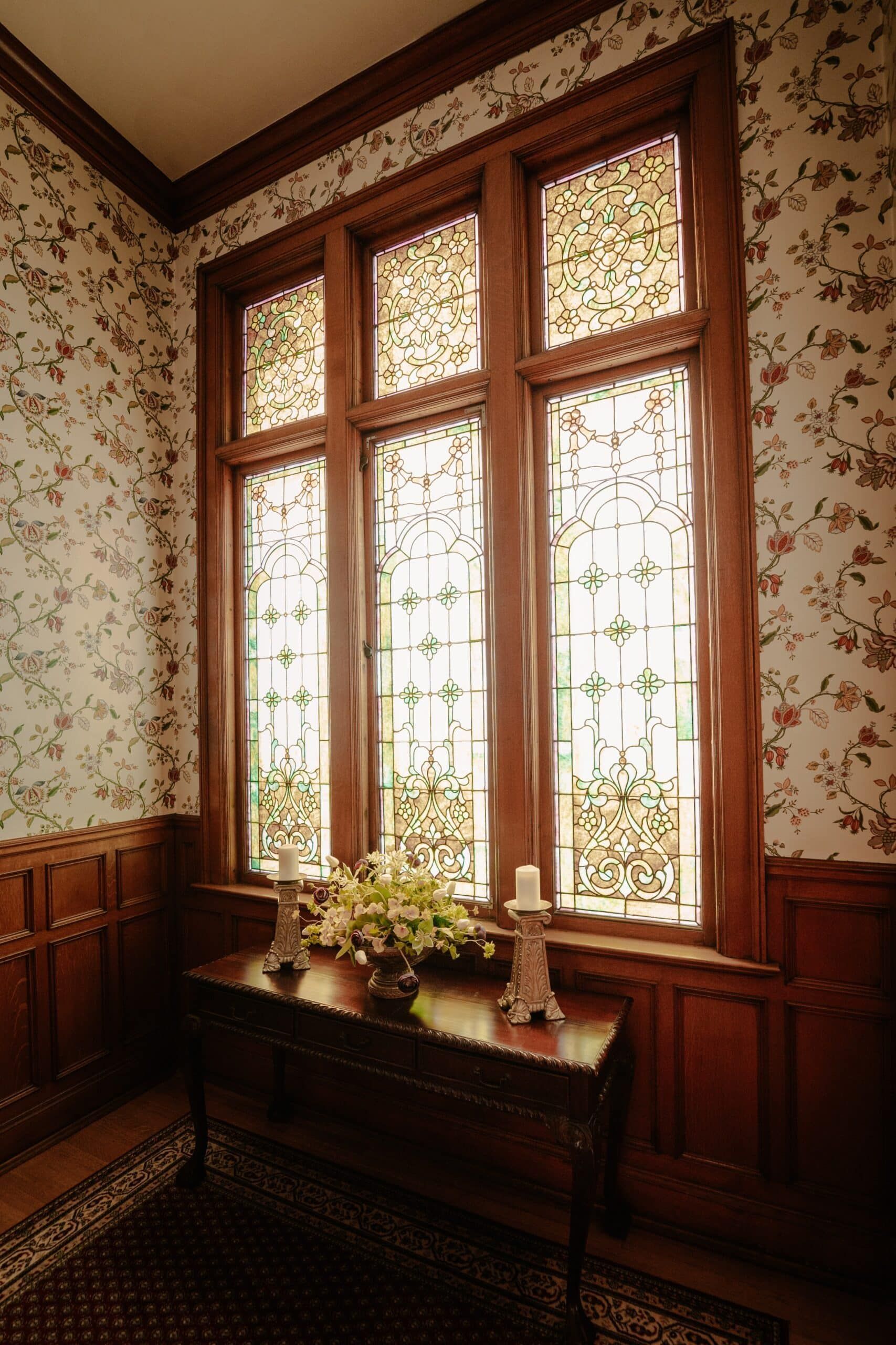 A room with stained glass windows and candles on a table