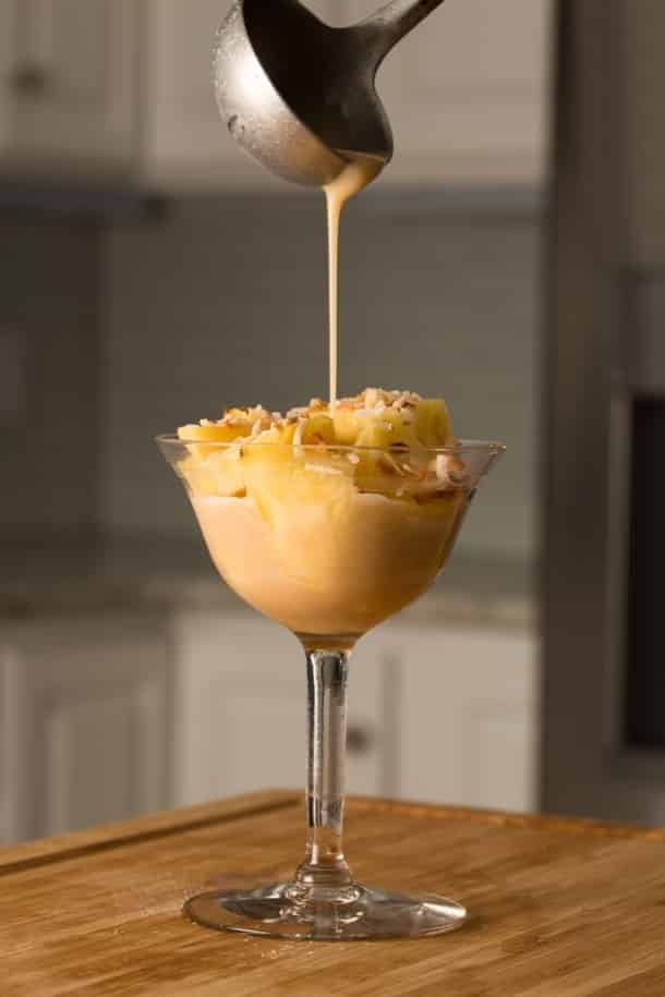 A bowl of food is being poured into a martini glass.