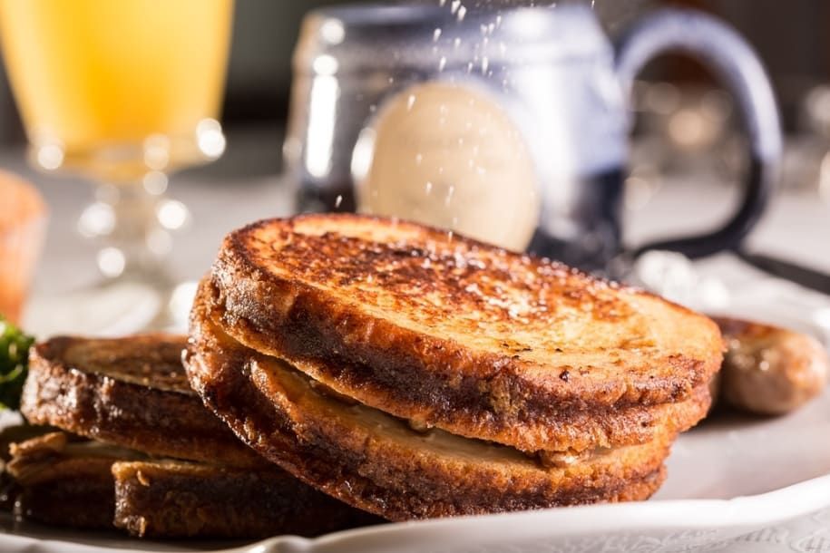 French toast is stacked on top of each other on a white plate.