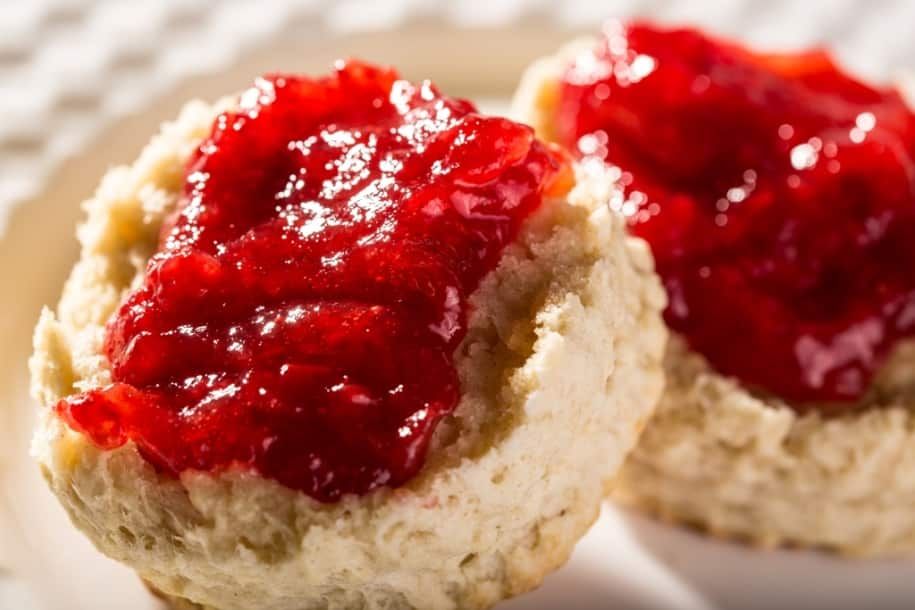 Two biscuits with strawberry jam on them on a plate