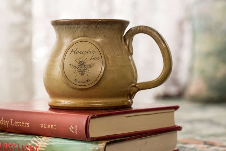A mug is sitting on top of a stack of books.