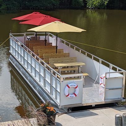 A boat with umbrellas and a life preserver on the side of it