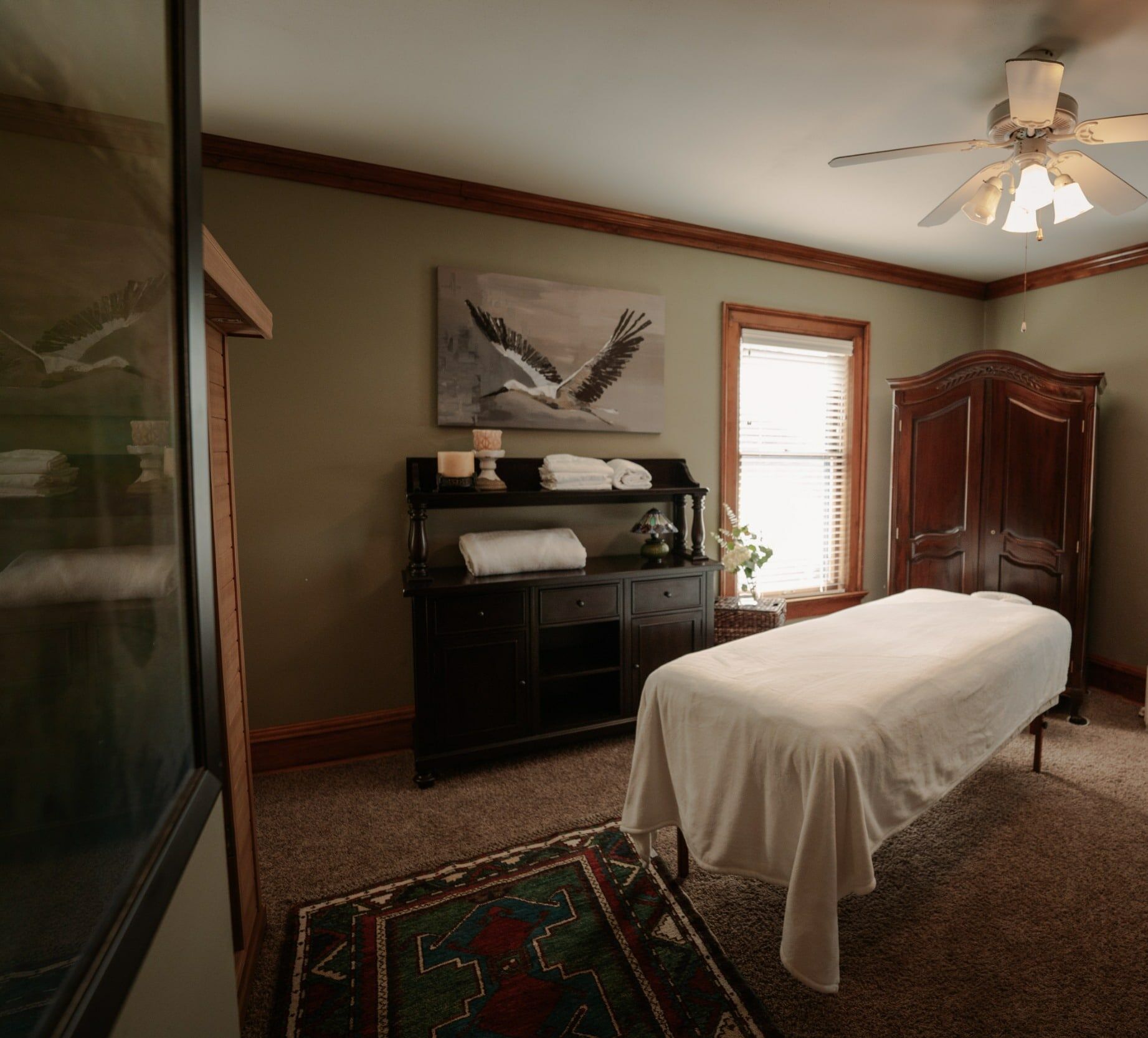 A room with a massage table and a ceiling fan