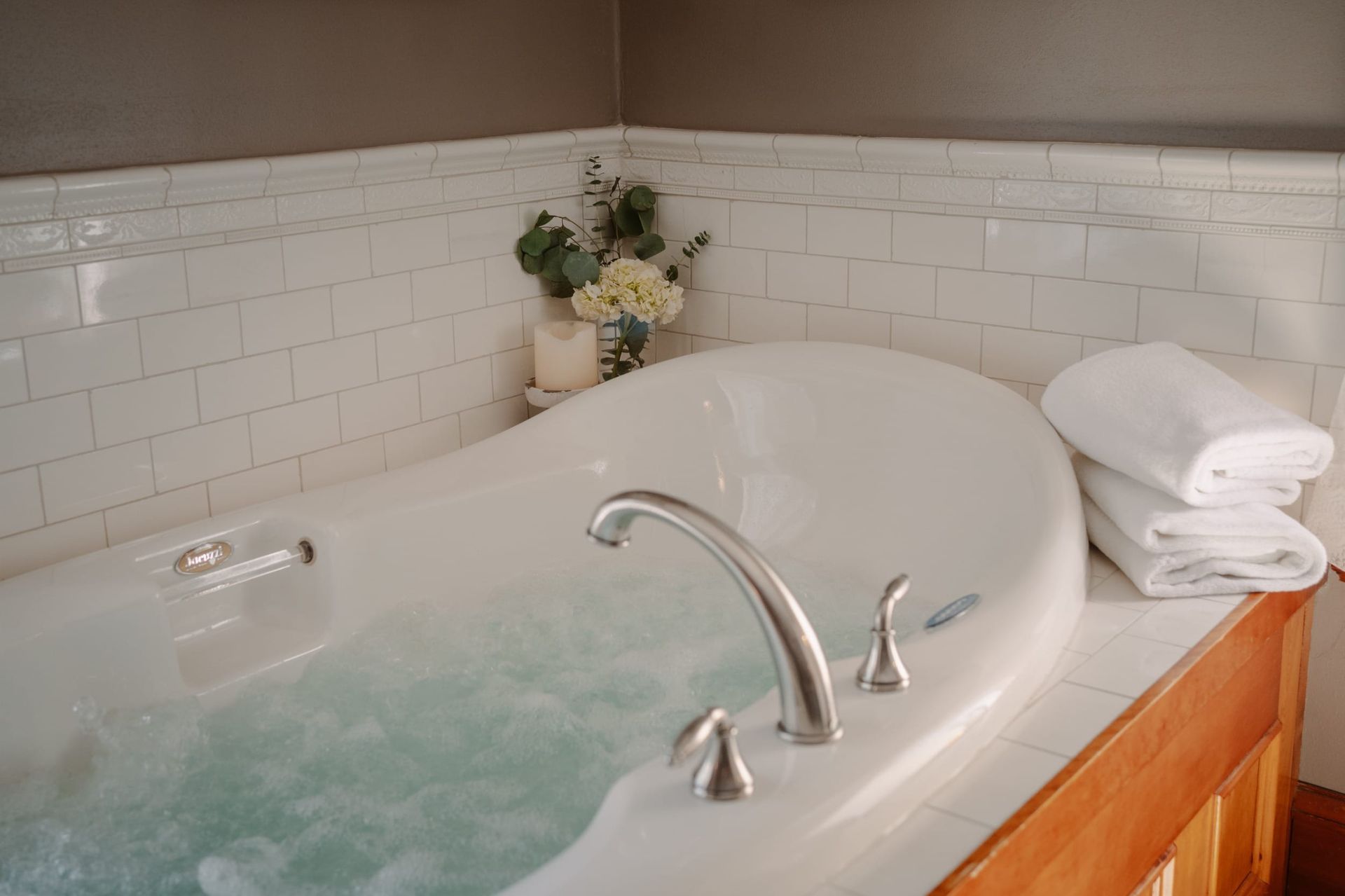 There is a jacuzzi tub in the corner of the bathroom.