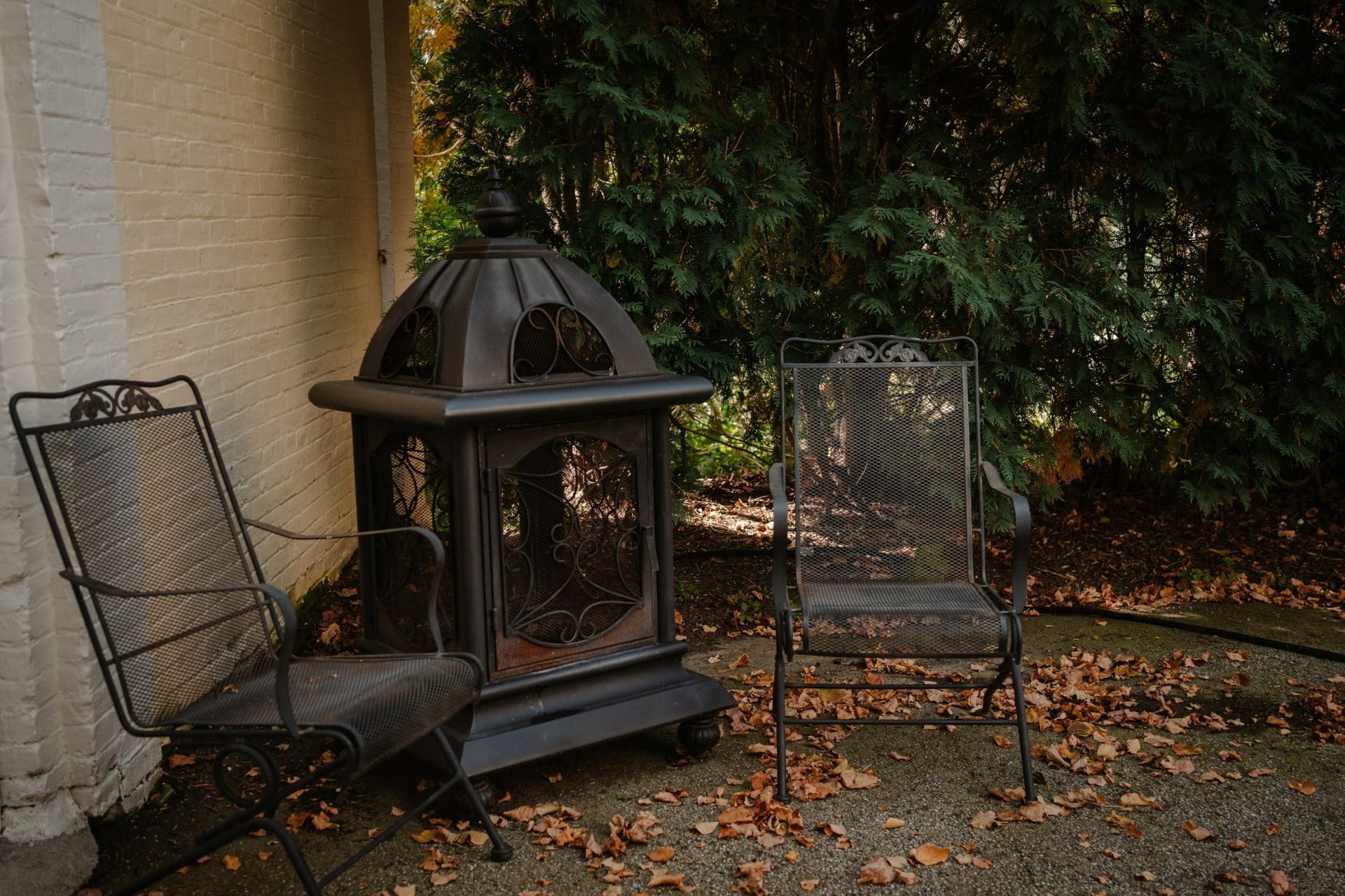 Two chairs and a lantern are sitting in front of a brick building.