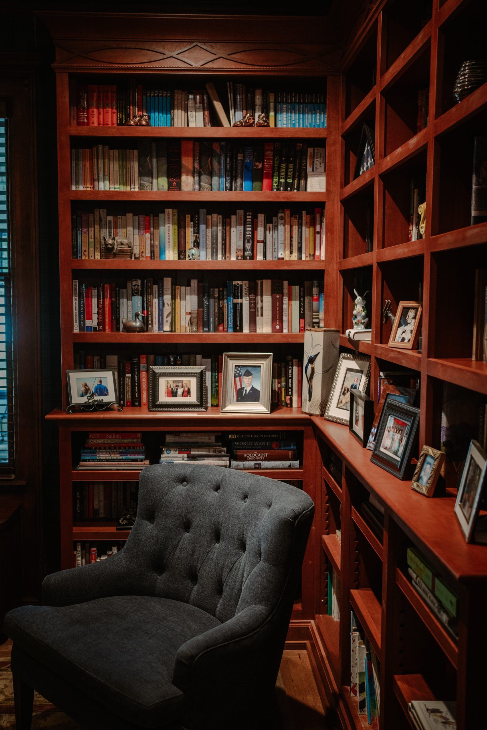 A chair is sitting in front of a bookshelf filled with books.