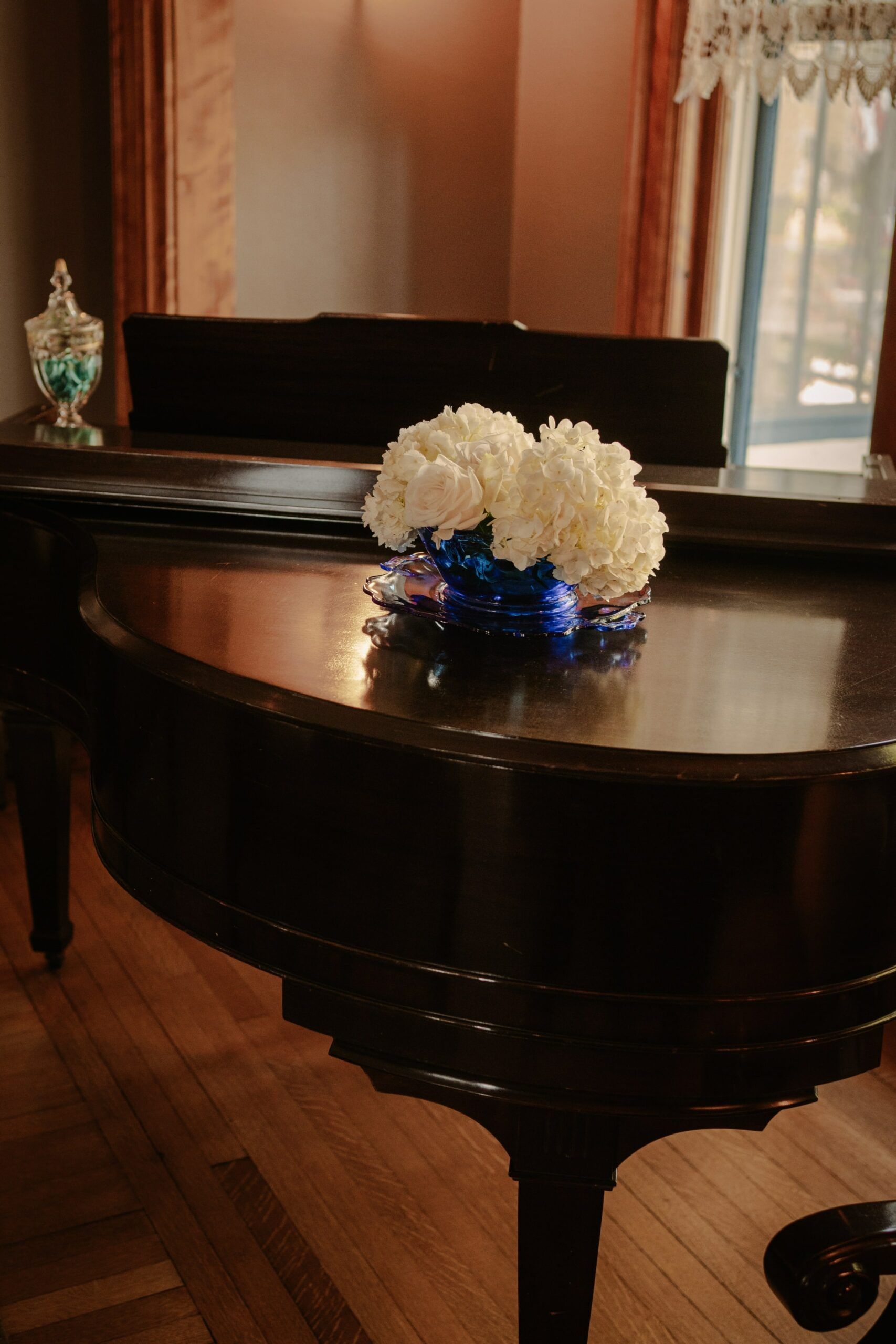 A piano with a vase of white flowers on it