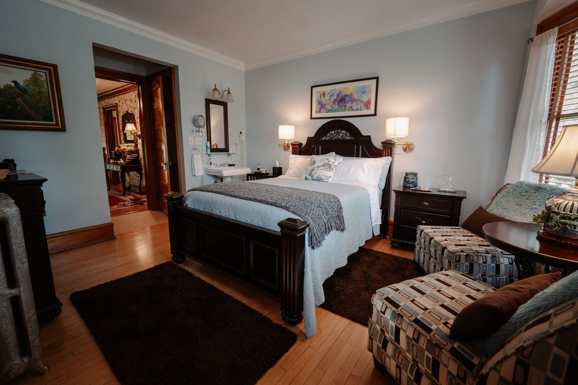 A bedroom with a king size bed , chairs , nightstands , and a rug.