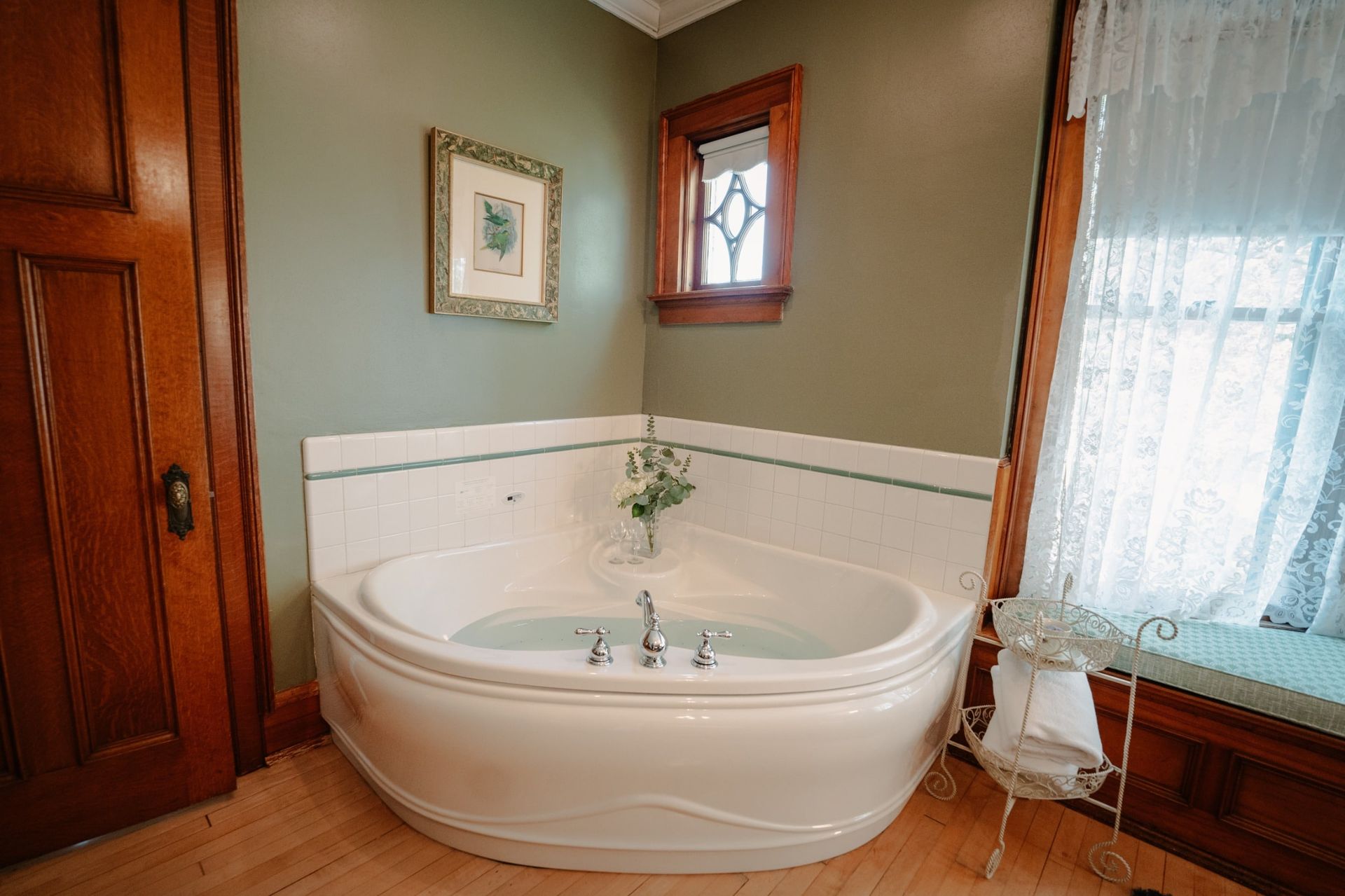 A bathtub in the corner of a bathroom next to a window.