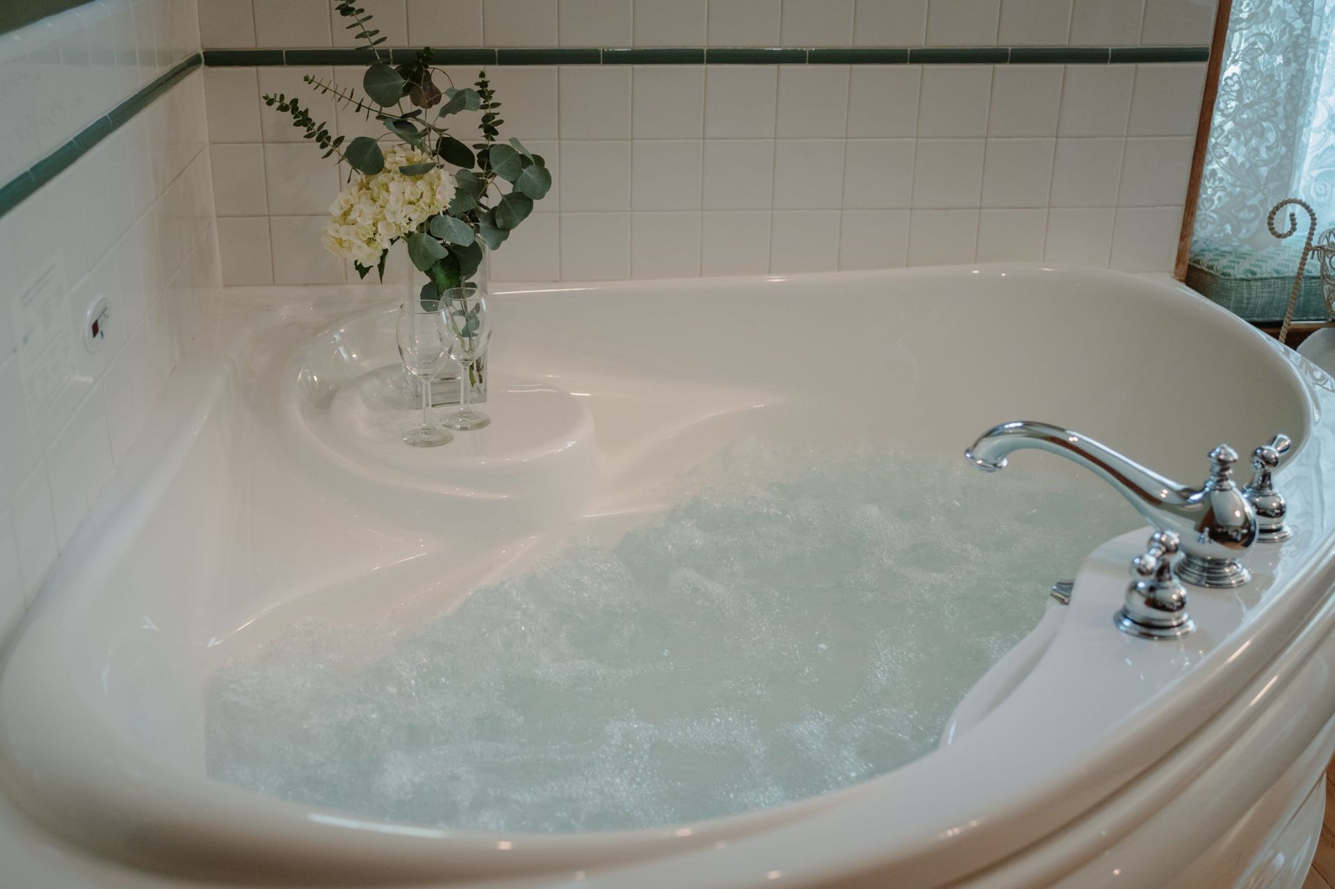 A bathtub with a vase of flowers on top of it