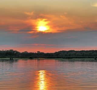 The sun is setting over a body of water.