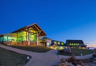 A large building with a lot of windows is lit up at night.
