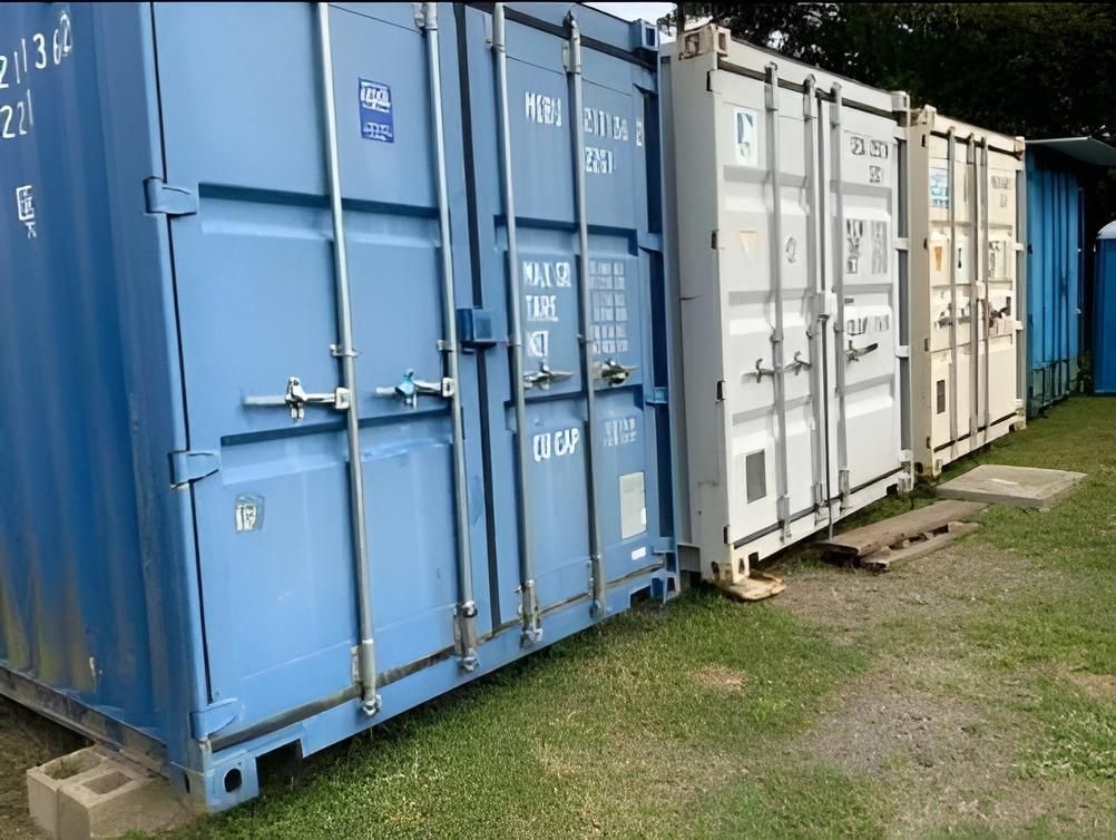 Blue and white shipping containers lined up outdoors on grass — Cairns Budget Storage In Mount Sheridan, QLD