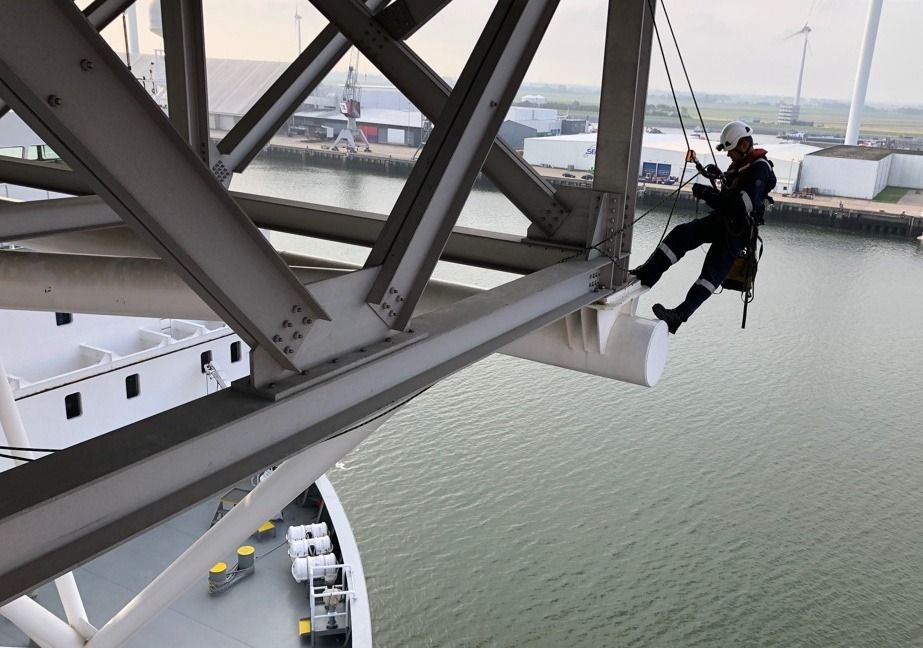 rope access worker inspecting steel over water