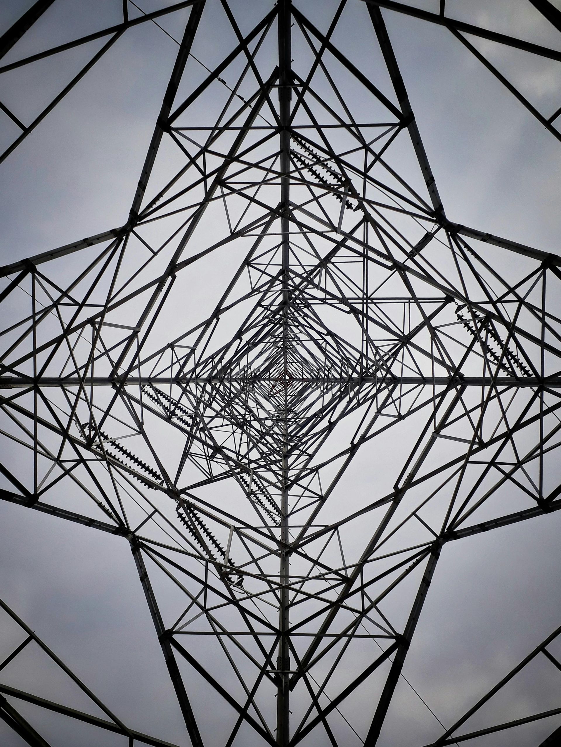 A black and white photo of a geometric structure against a cloudy sky