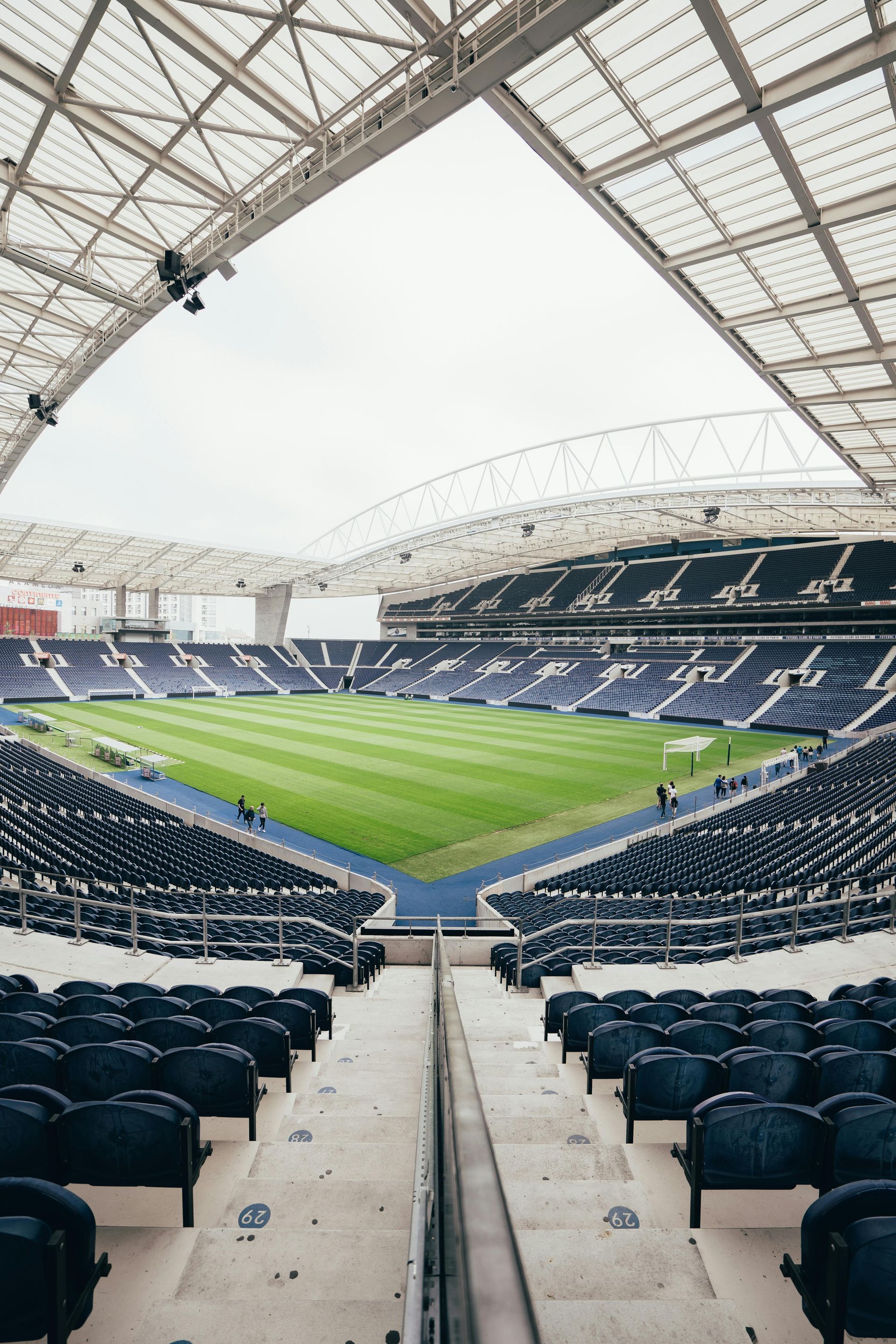 A football stadium with empty seats and a roof.