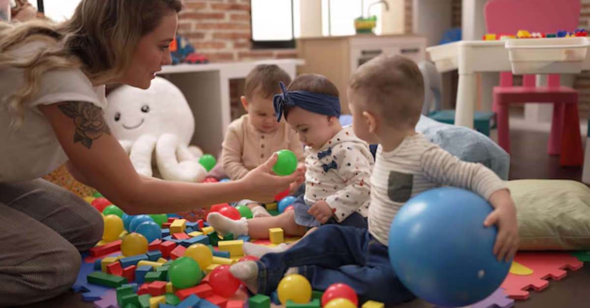 A woman and three babies are playing with toys on the floor.