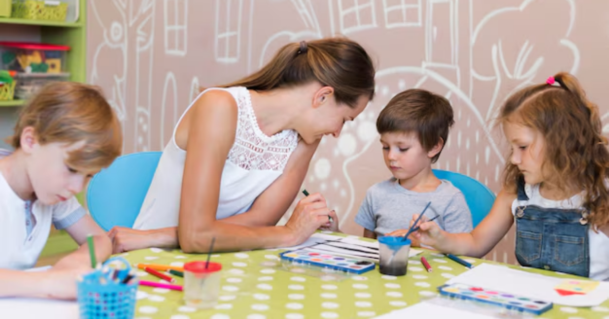 A group of children are sitting at a table painting with watercolors.