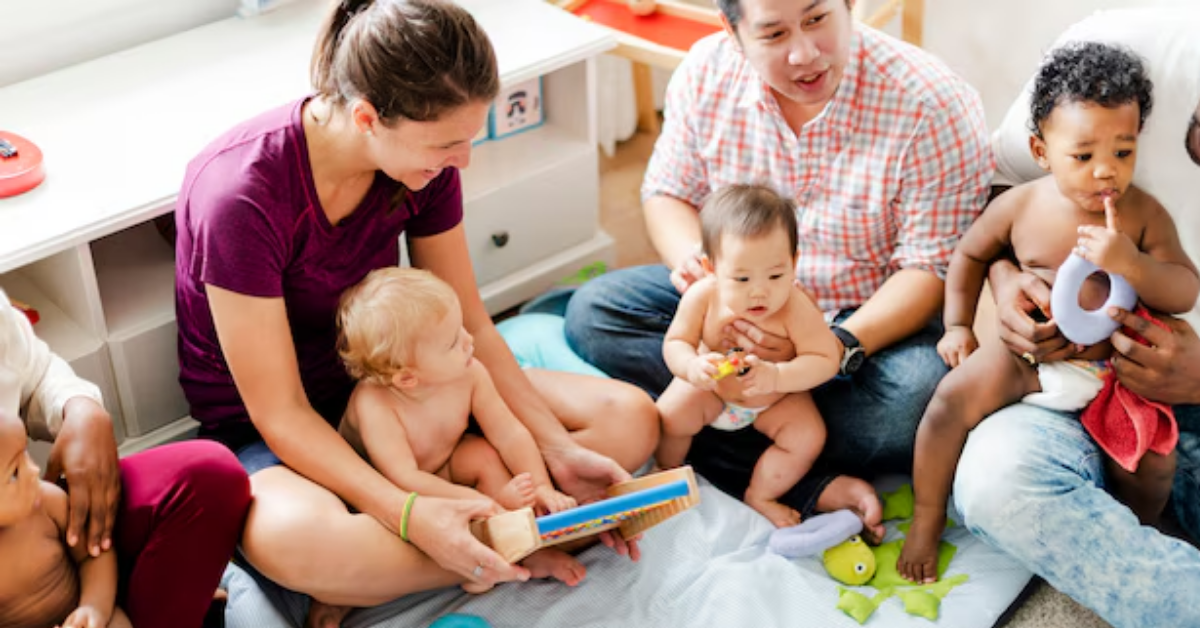 A group of people are sitting on the floor with their babies.