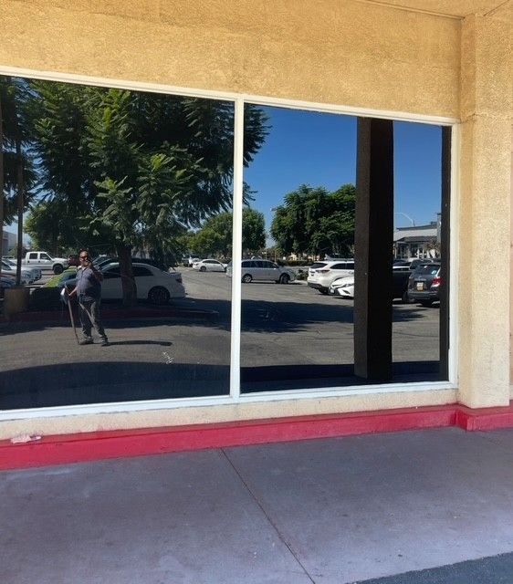 Red "SALE!" sign on a store window, reflecting an interior and exterior view.
