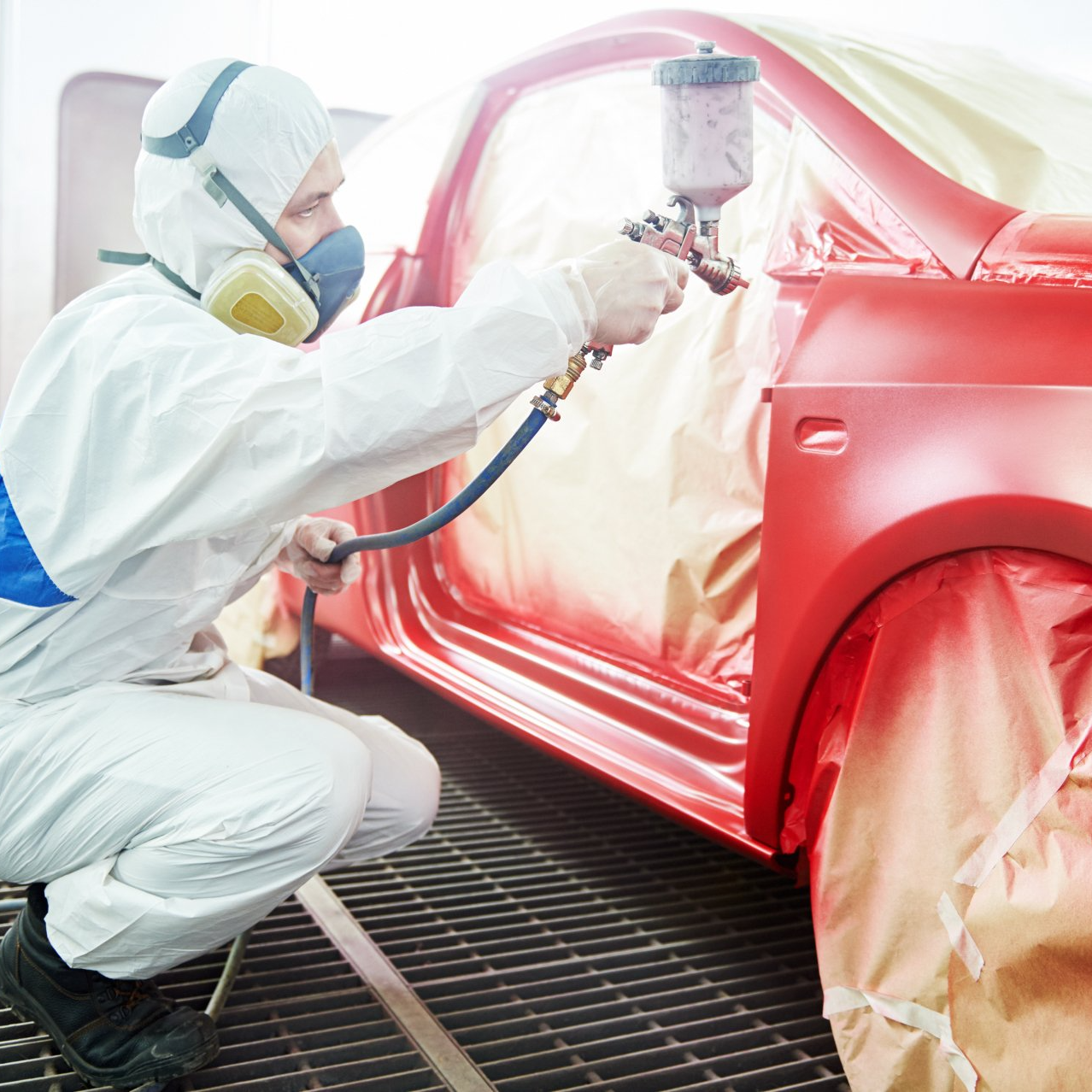 auto mechanic worker painting a red car