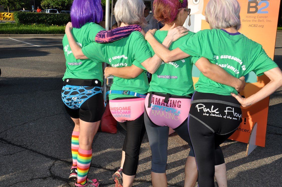 A group of women wearing green shirts are hugging each other