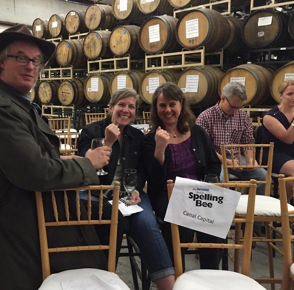 People sitting in chairs with a sign that says spelling bee