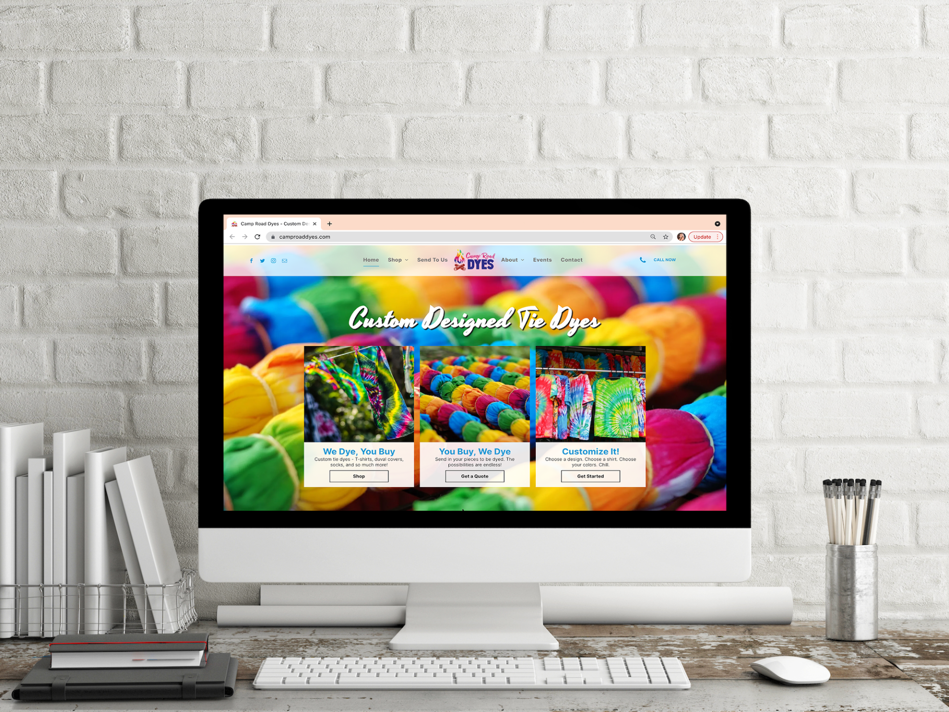 A computer monitor is sitting on a desk in front of a brick wall.